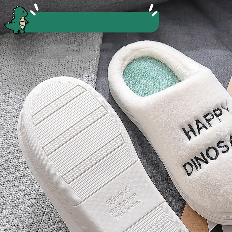 White slippers with 'Happy Dinos' text on a gray surface