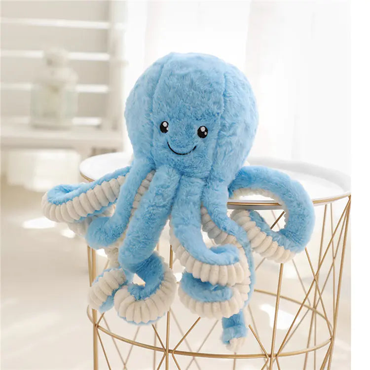 Blue plush octopus toy on a gold wire stool with a blurred background