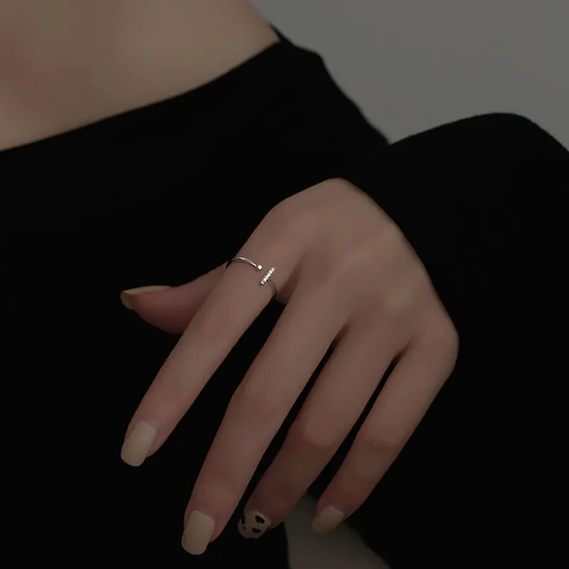 Hand wearing a gold ring with a black background
