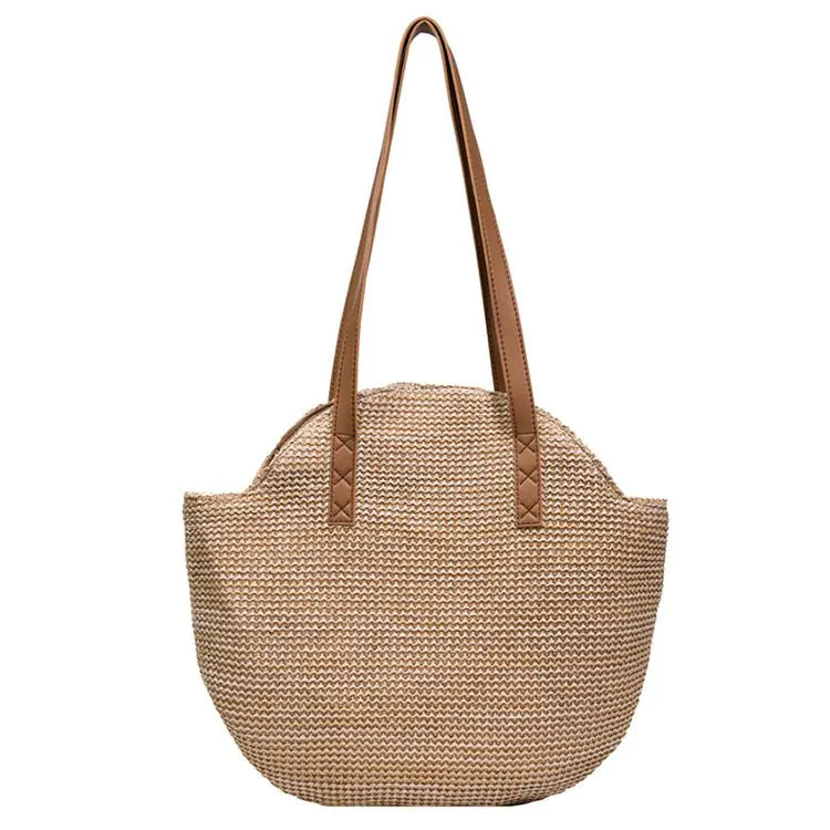 Beige woven handbag with brown leather straps on a white background