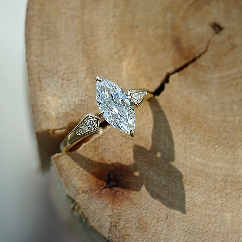 Gold ring with a large diamond on a wooden surface