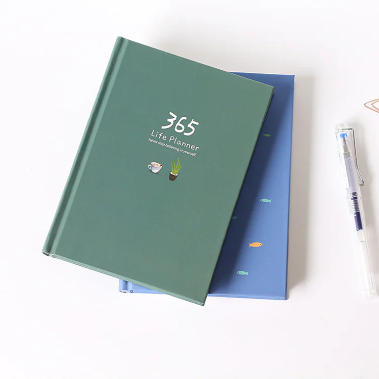 Green '365 Life Planner' on a white background with a pen to the right.