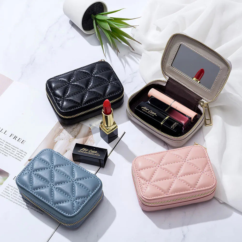 Quilted jewelry cases with lipsticks and makeup items on a white surface.