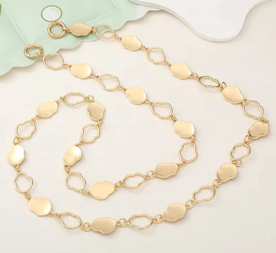 Gold chain necklace on a light background