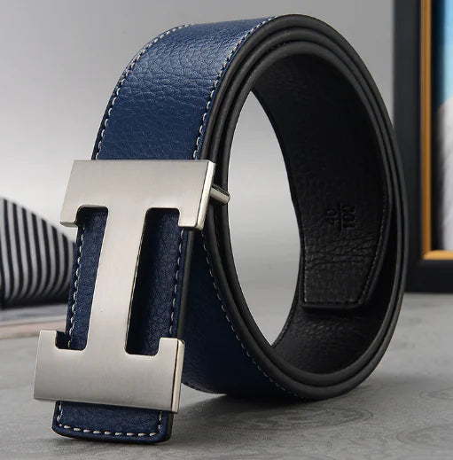 Blue and black leather belt with silver buckle on a light gray surface.