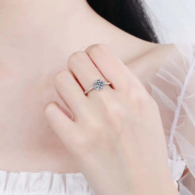 Close-up of a hand wearing a diamond ring with a soft focus background