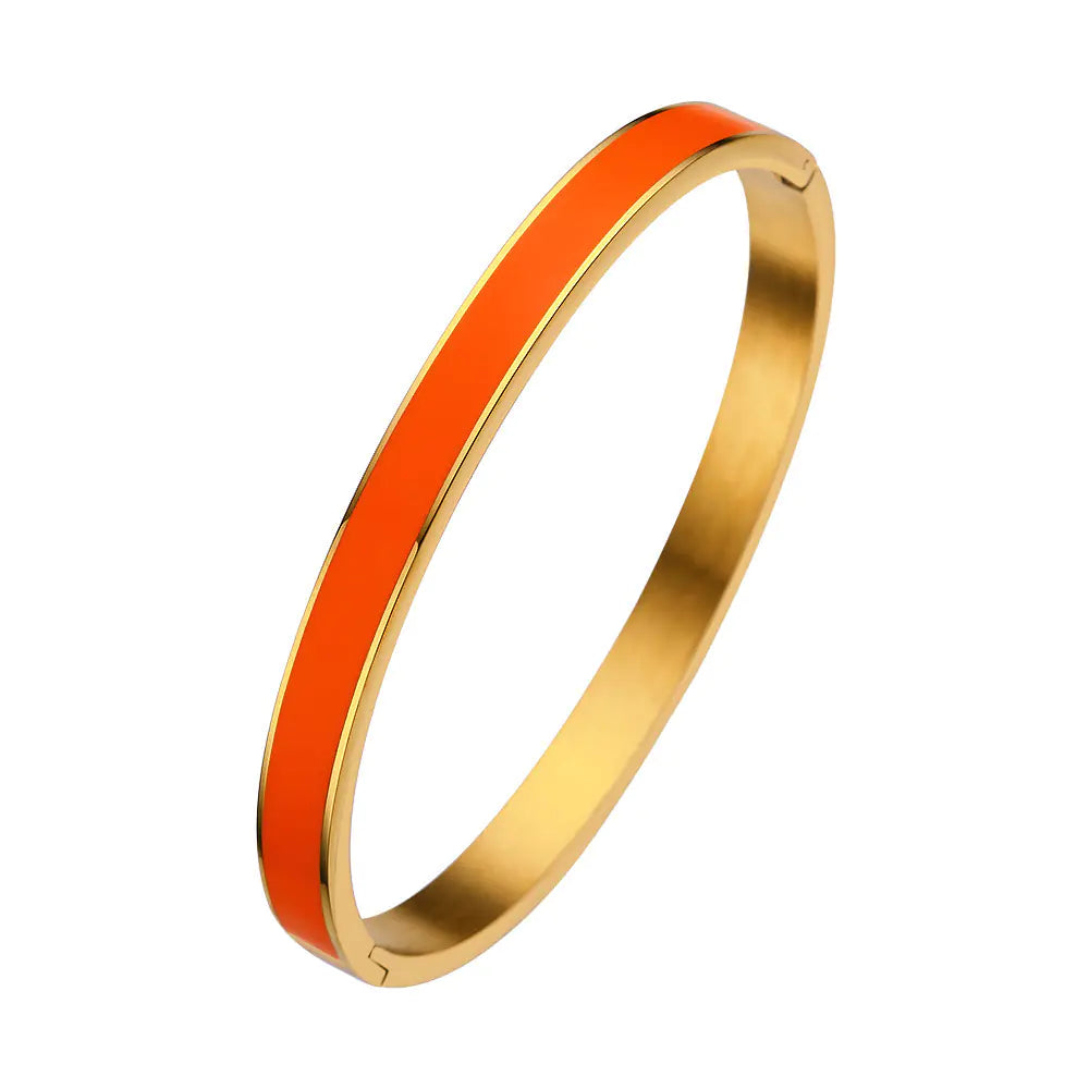 Gold bangle with an orange interior on a white background