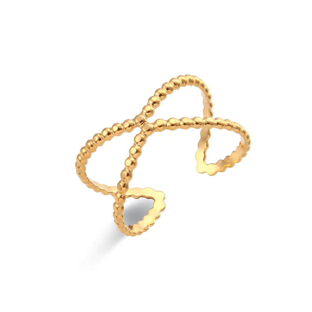 Gold ring with a heart design on a white background
