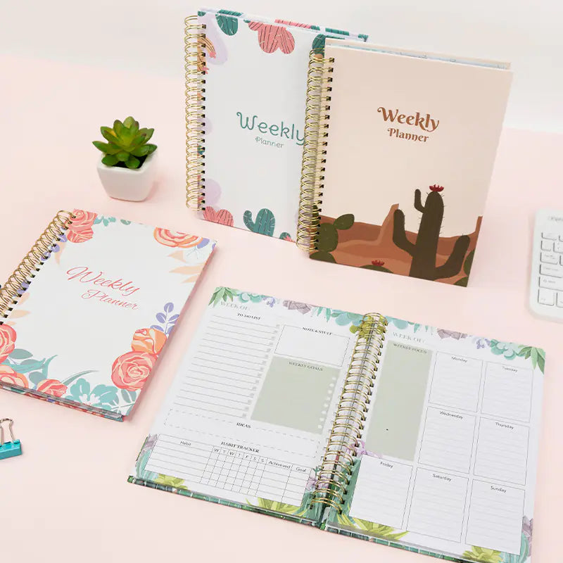 Weekly planner with floral design on a light pink surface