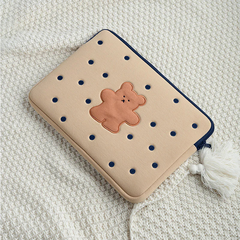 Beige cushion with blue holes and a bear-shaped patch on a textured surface
