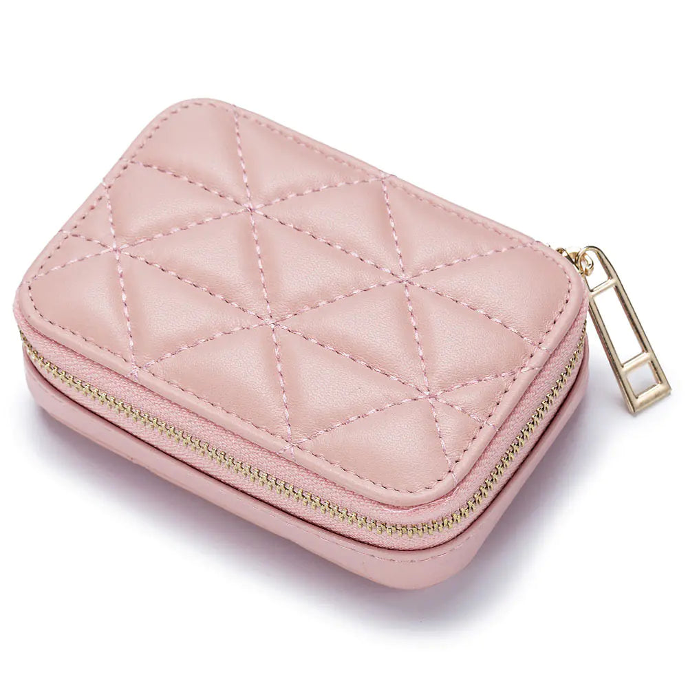 Pink quilted jewelry case with gold zipper on a white background