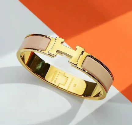 Gold and rose gold bracelet on a white and orange background