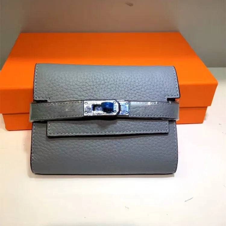 Gray textured wallet with silver buckle on an orange box