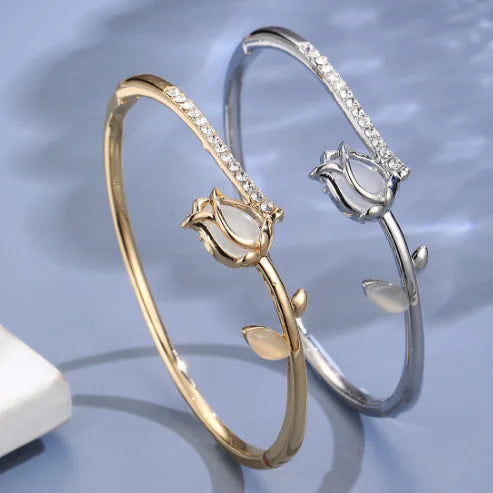 Gold and silver rose-shaped bangles on a light blue background