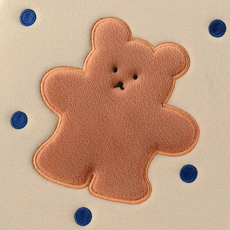 Brown teddy bear patch on a beige background with blue polka dots