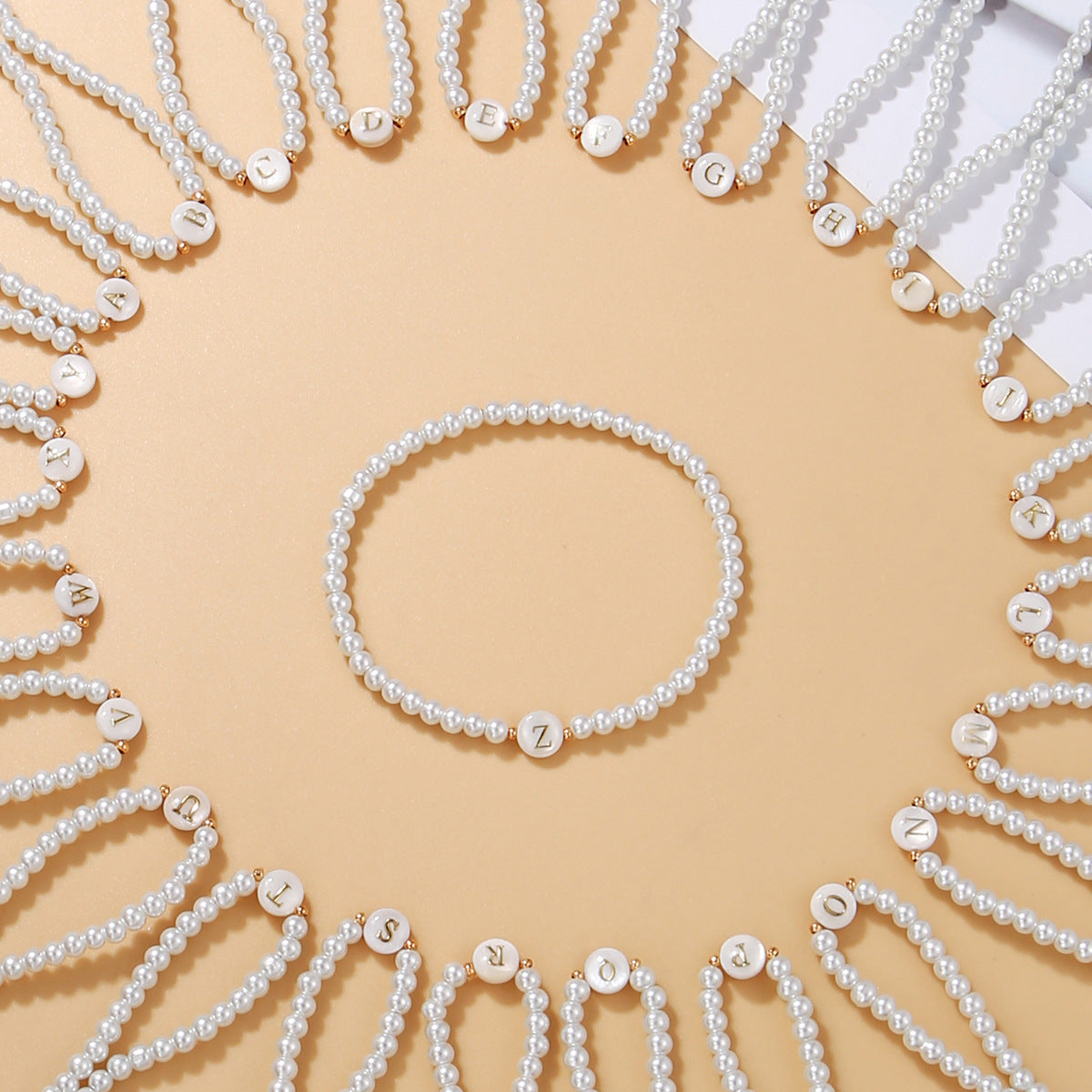 Pearl jewelry set including necklaces and a bracelet on a beige background