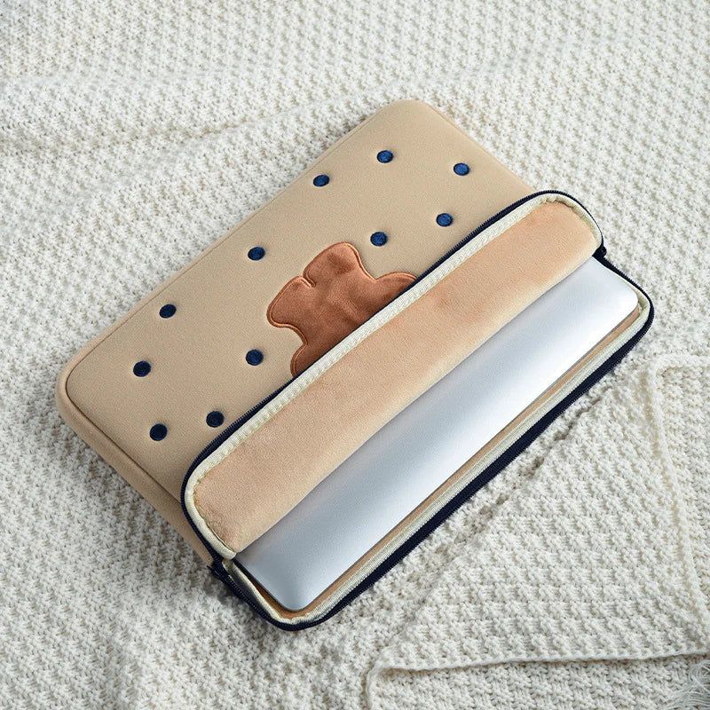 Beige laptop sleeve with brown patch and blue polka dots on a textured surface