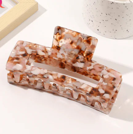 Two tortoiseshell patterned hair clips on a white surface.