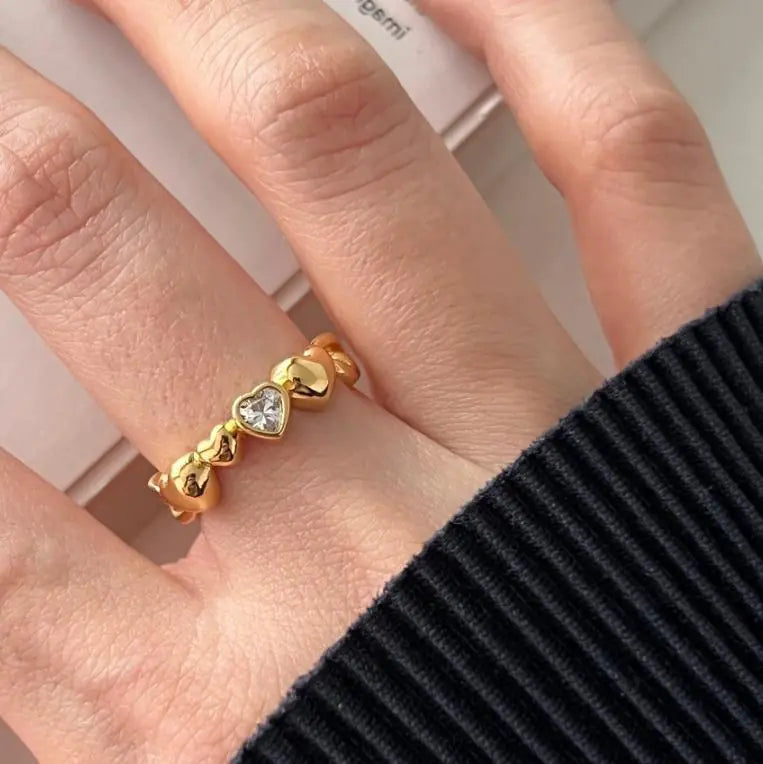 Gold ring with heart-shaped gemstone on a hand