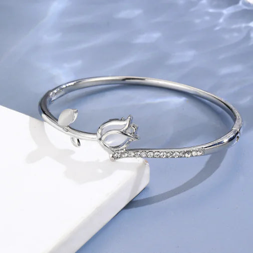 Silver bracelet with a decorative element on a light blue background