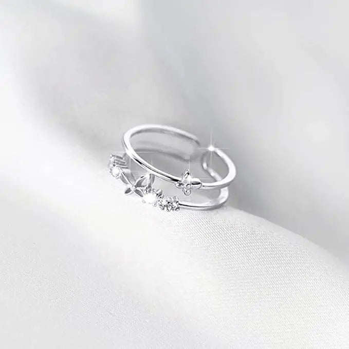 Silver ring with floral design on a white fabric background