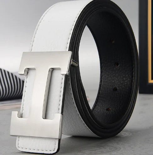 White leather belt with silver buckle and black leather strap on a light gray background