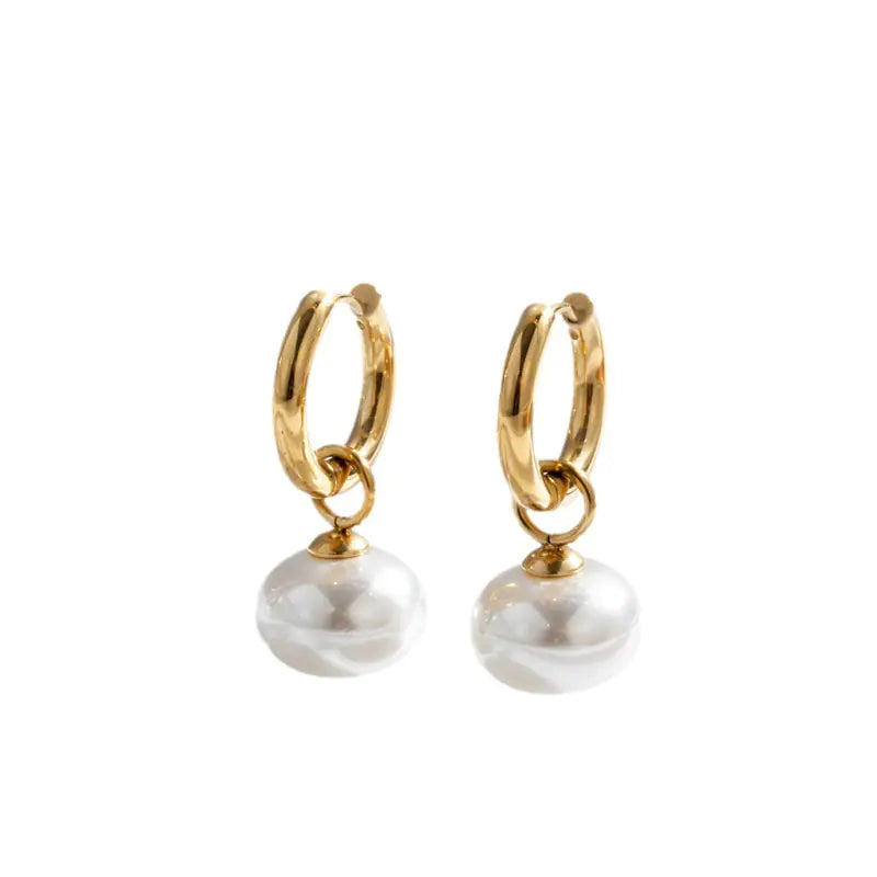 Gold hoop earrings with pearl drops on a white background