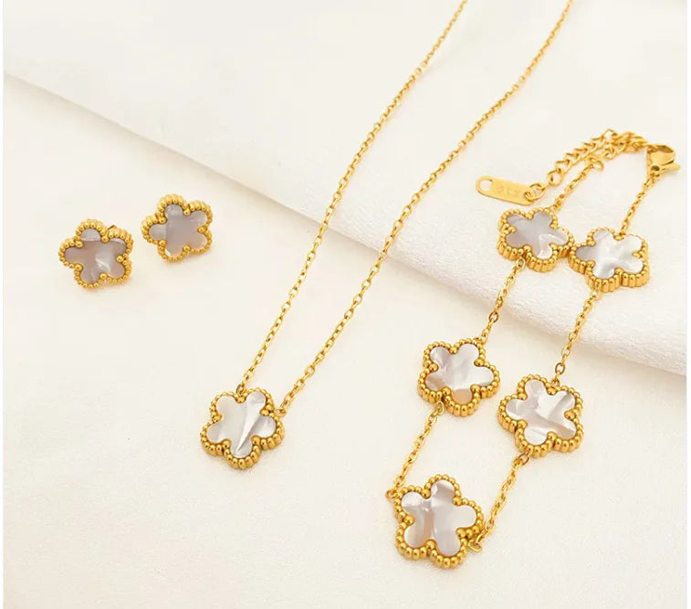 Gold jewelry set with floral designs on a light background