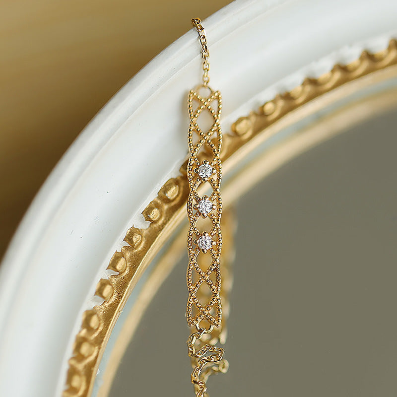 Gold earring with diamond accents on a white surface