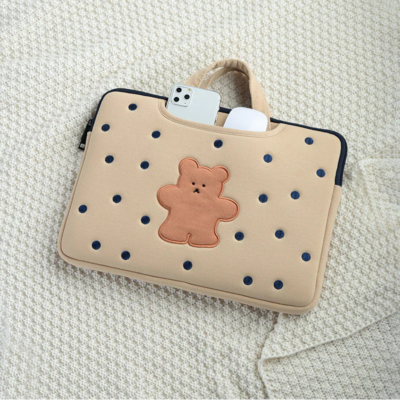 Beige laptop sleeve with teddy bear design on a textured surface