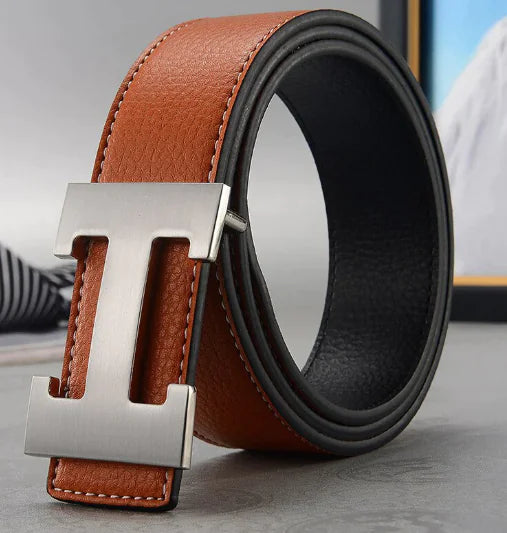 Brown and black leather belt with silver buckle on a neutral background
