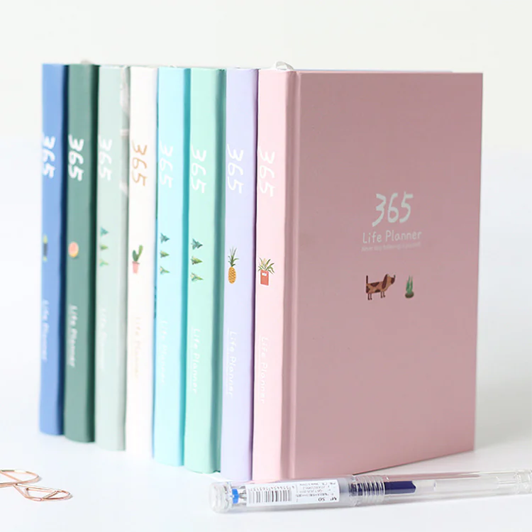 Set of colorful planners with a pink one featuring a dog illustration on a white background.