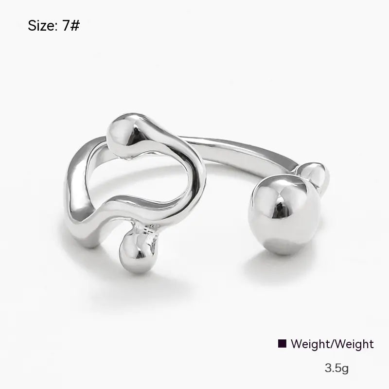 Silver open ring with a heart and ball design on a white background