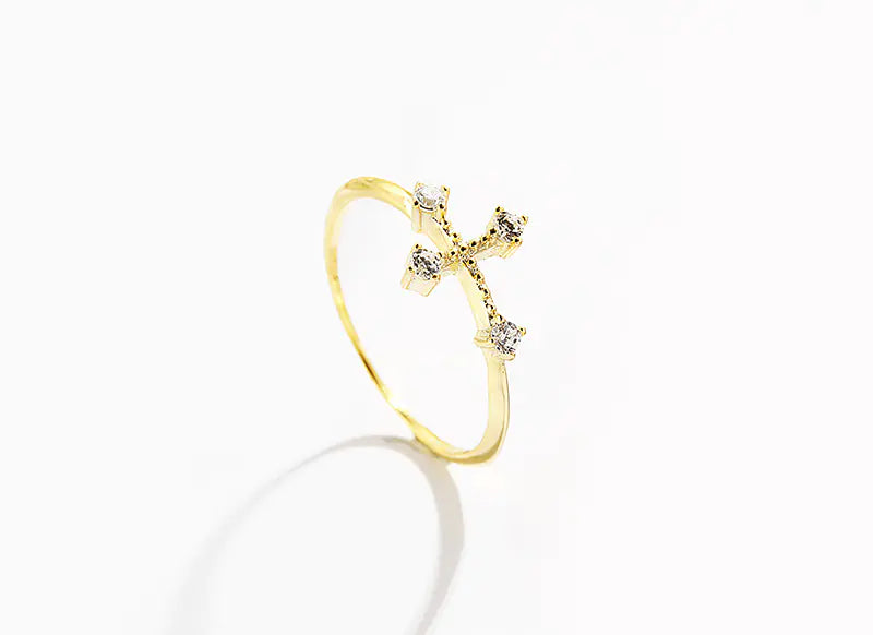 Gold ring with a cross design on a white background