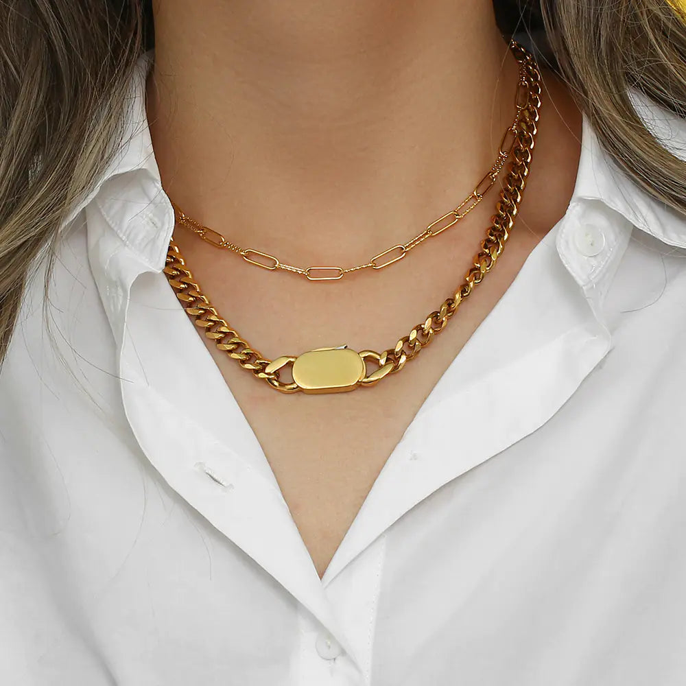 Gold chain necklaces on a person wearing a white shirt