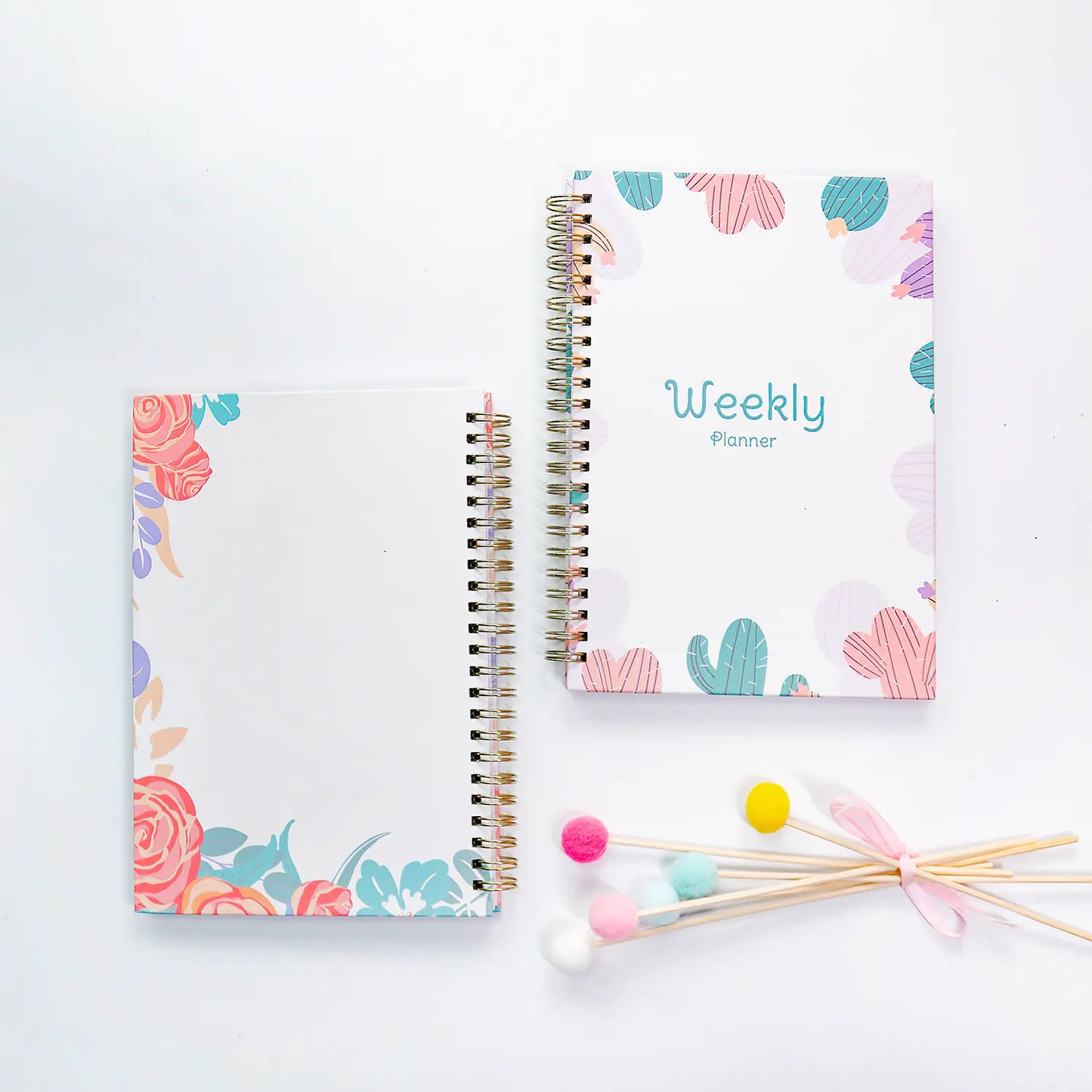 Two spiral-bound planners with floral and cactus designs on a white background.