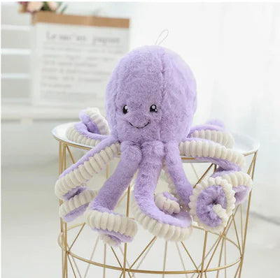 Purple plush octopus toy on a gold wire stool with a white background
