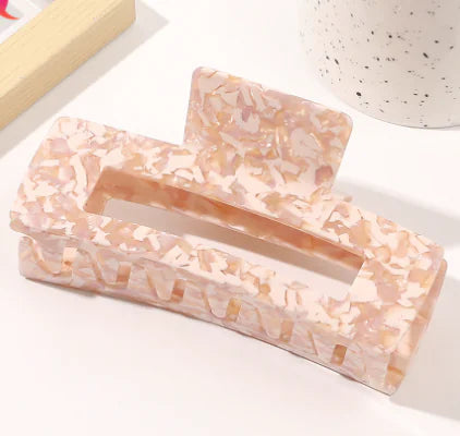 Marble-patterned hair clip on a white surface