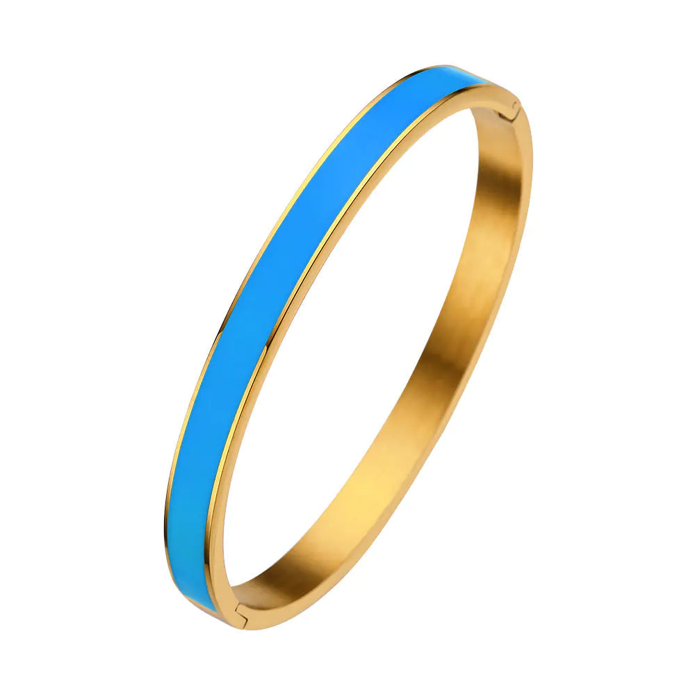 Gold bangle with a blue stripe on a white background