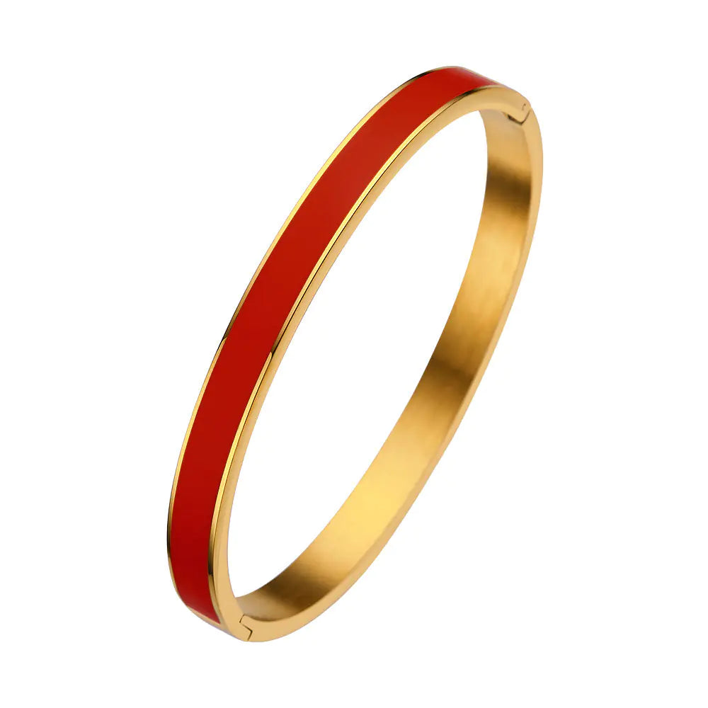 Gold bangle with a red interior on a white background
