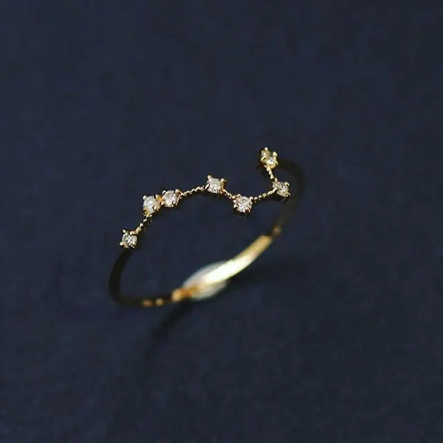 Gold ring with small diamonds on a dark blue background