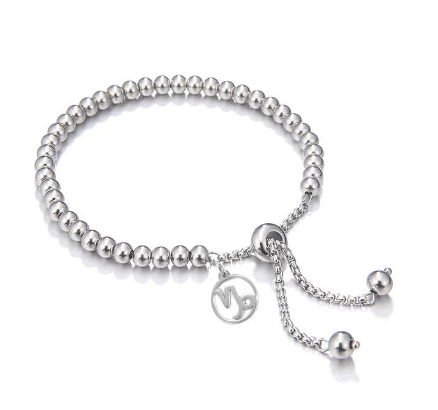 Silver beaded bracelet with a charm on a white background