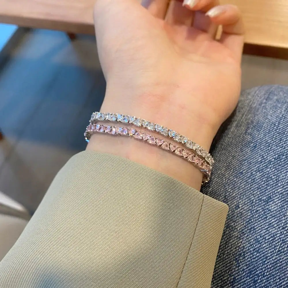 Close-up of a hand wearing two diamond bracelets on a blurred background