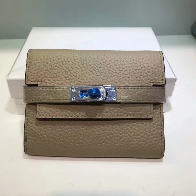 Beige leather wallet with decorative clasp on a white background