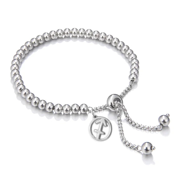 Silver beaded bracelet with a charm on a white background