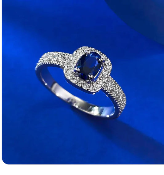 Silver ring with a blue gemstone on a blue background