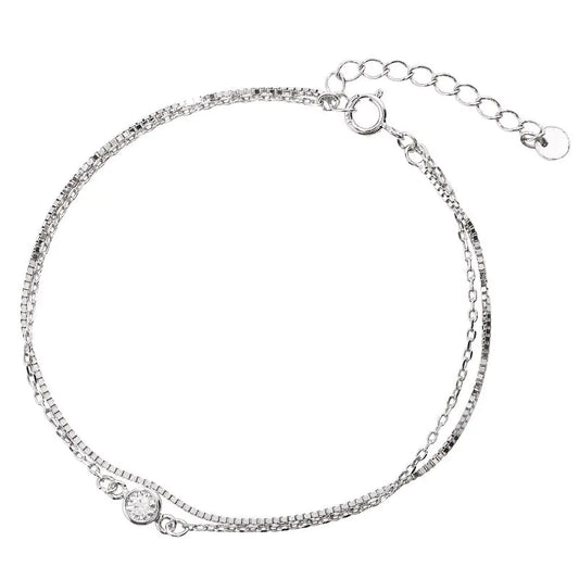 Silver bracelet with a small round clasp on a white background