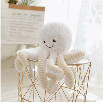 Plush octopus toy on a small round table with a light background