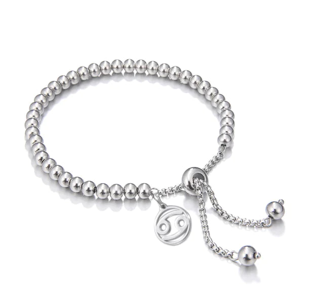 Silver beaded bracelet with a zodiac charm on a white background