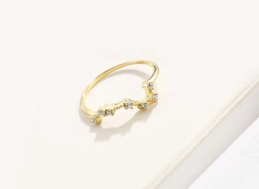 Gold ring with small diamonds on a light background